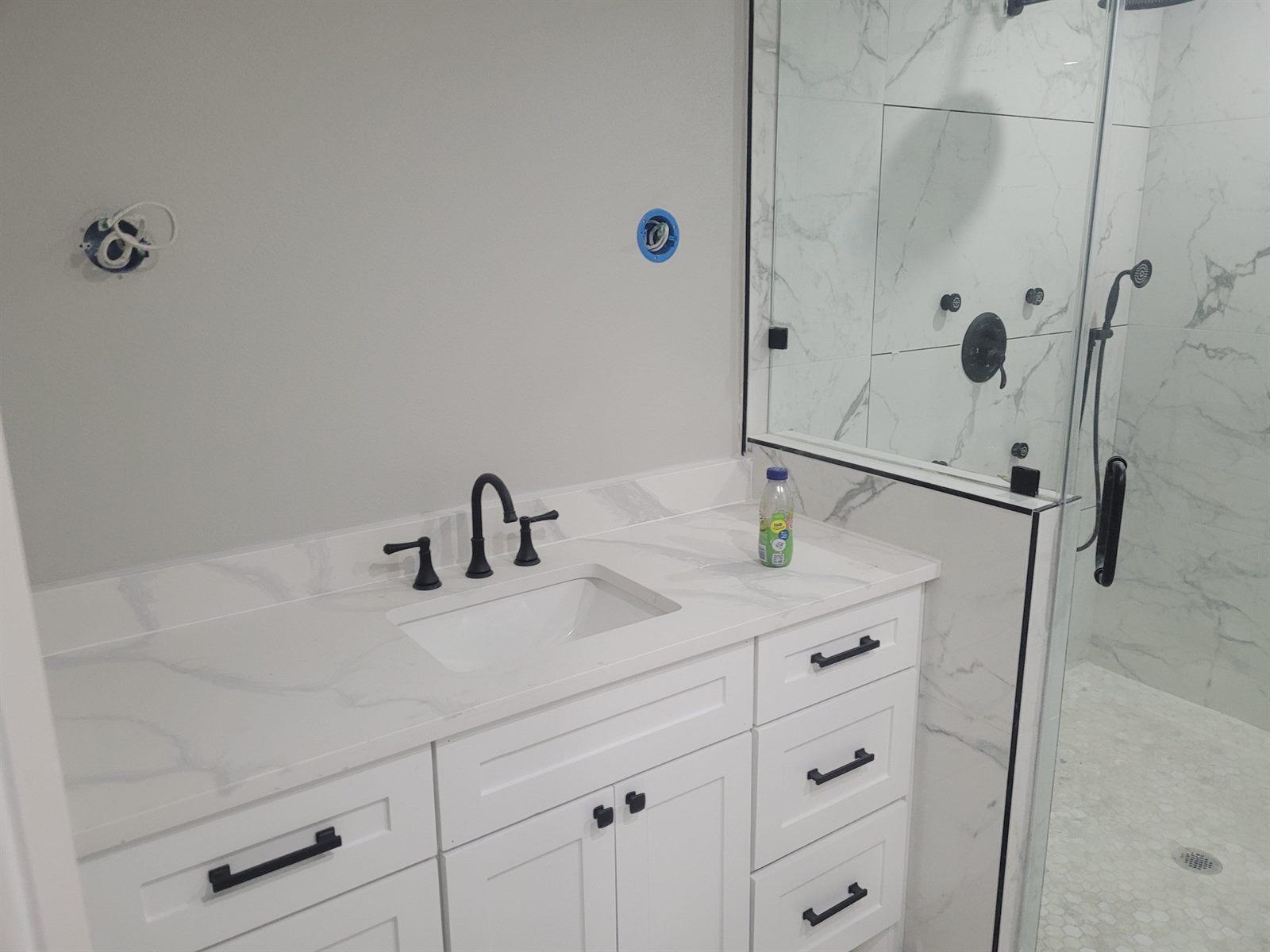 Marble bathroom with a glass-enclosed shower and a modern vanity
