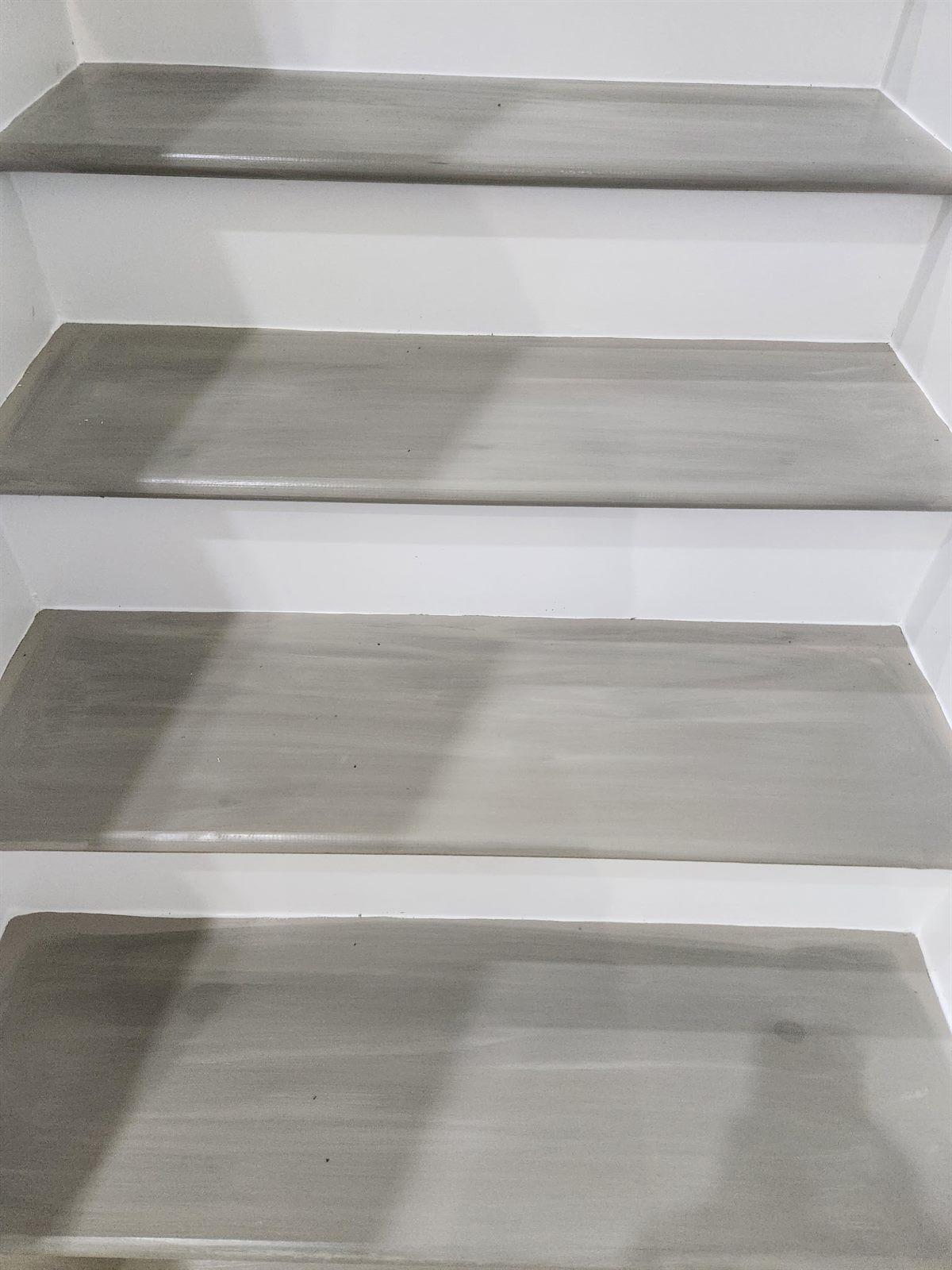 Modern floating staircase with light wood treads against a white wall