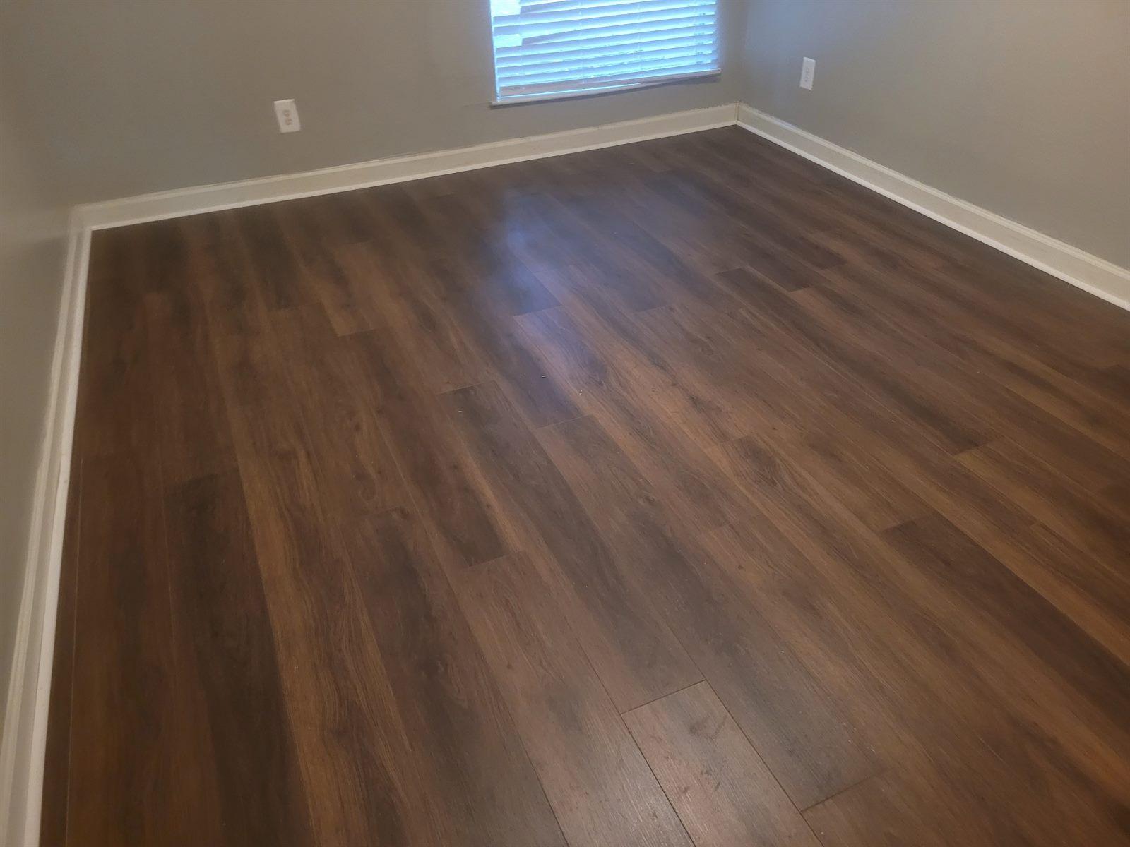 Freshly installed dark hardwood flooring in a bright, finished room