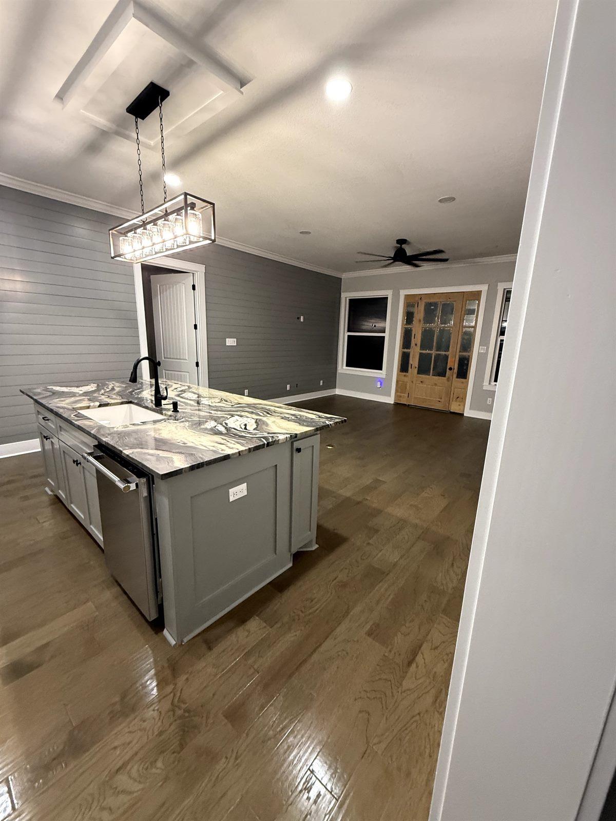Custom kitchen featuring a marble waterfall island and white cabinetry
