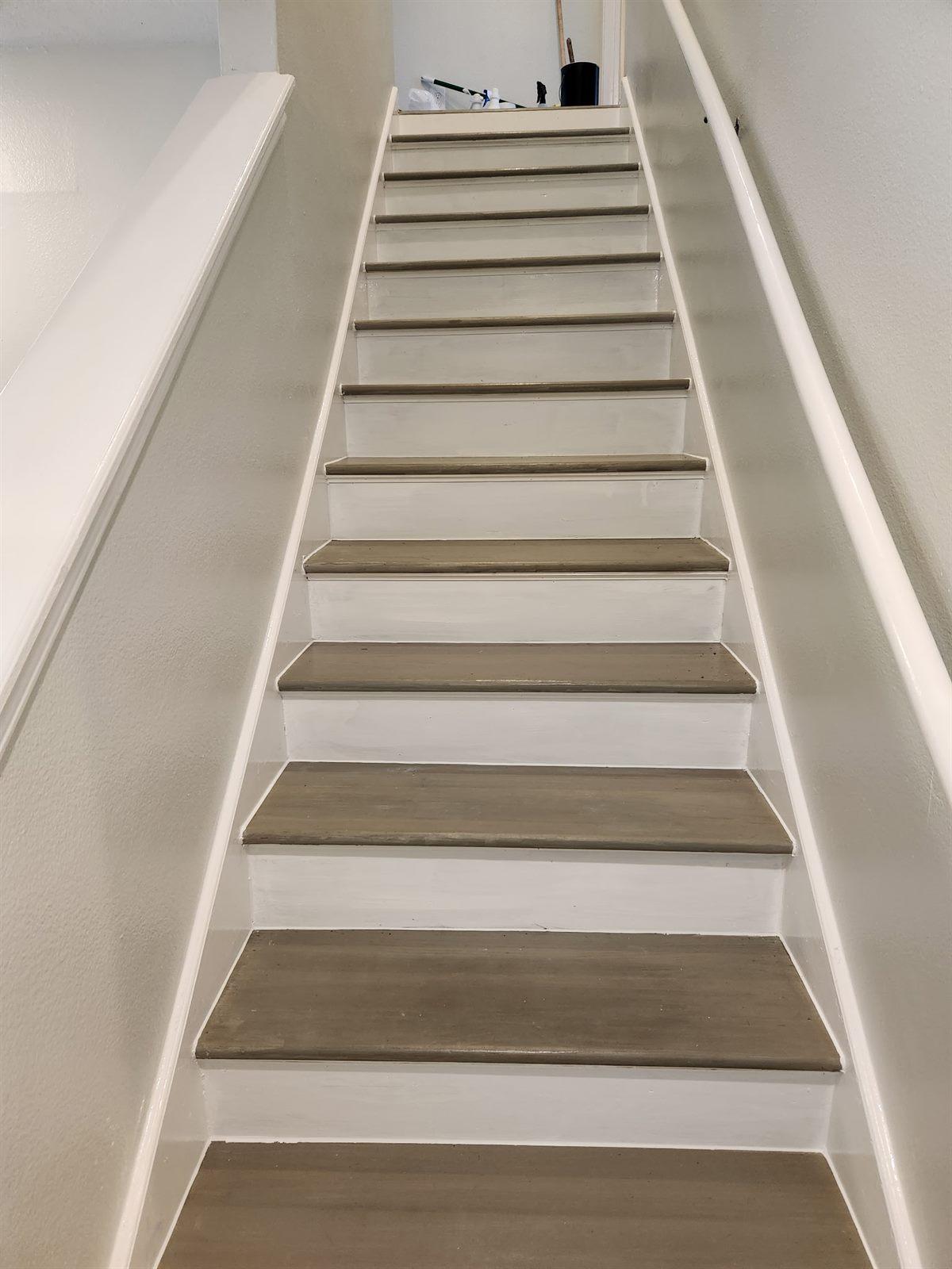 Refinished staircase with natural wood treads and crisp white risers